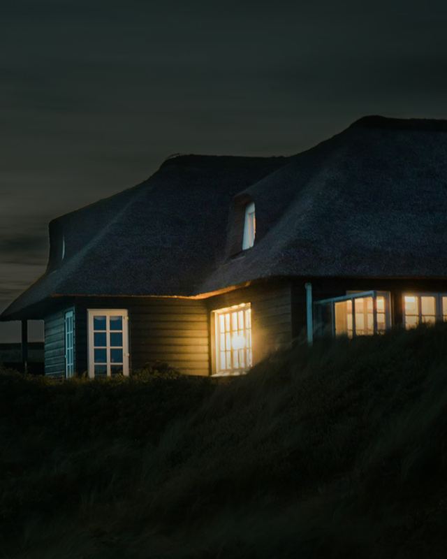 A house at night with light shining from its windows